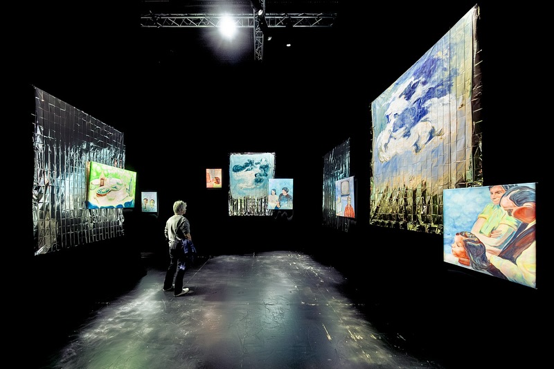 Vue de l'exposition les illusion retrouvées, Biennale Nemo au Cent Quatre Paris, peintures de Caroline Delétoille dans une salle obscure et couvertures de survie