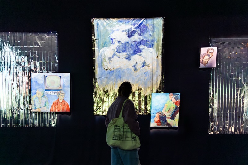 Vue de l'exposition les illusion retrouvées, Biennale Nemo au Cent Quatre Paris, peintures de Caroline Delétoille dans une salle obscure et couvertures de survie